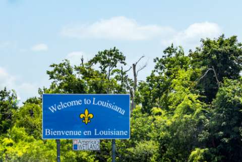 a roadside sign welcoming people to Louisiana, in English and French