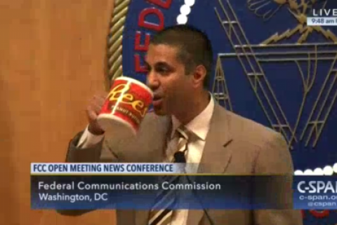 FCC Chairman Ajit Pai drinks from a large mug with the Reese's peanut butter cup logo