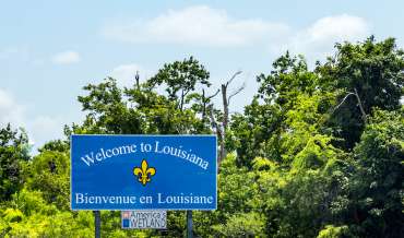 a roadside sign welcoming people to Louisiana, in English and French