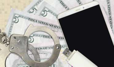 still life with handcuffs, smartphone, flash drive, and five dollar bills (american)