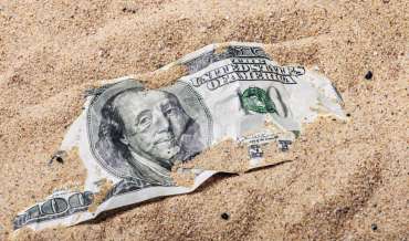 100 dollar bill buried in the sand