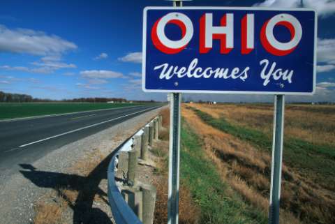 An "OHIO Welcomes You" sign by the side of a highway