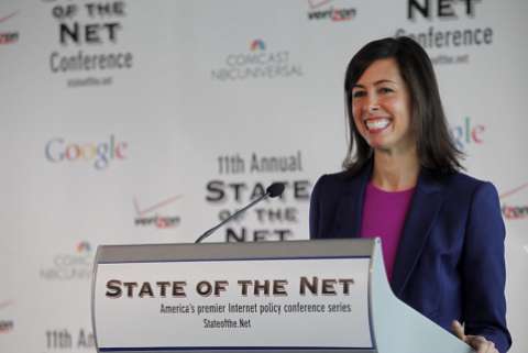 FCC Acting Chair Jessica Rosenworcel smiles while standing at a podium