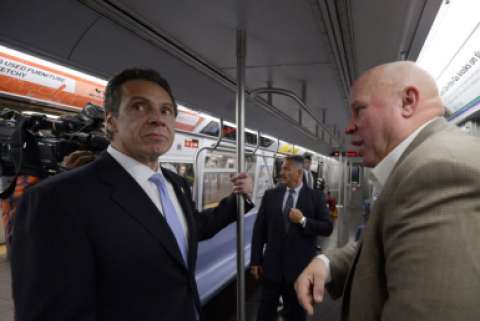 New York Governor Andrew Cuomo unhappily rides the subway with a bald man
