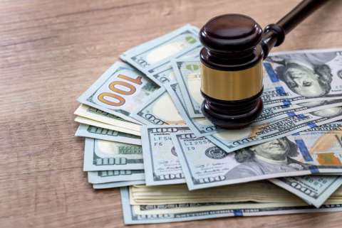 A gavel on top of a stack of hundred dollar bills