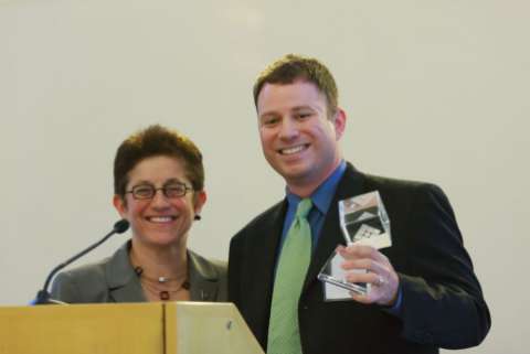 Gigi Sohn smiles with Mike Masnick, who is holding some sort of award