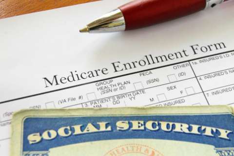 A pen, a medicare enrollement form, and a social security card
