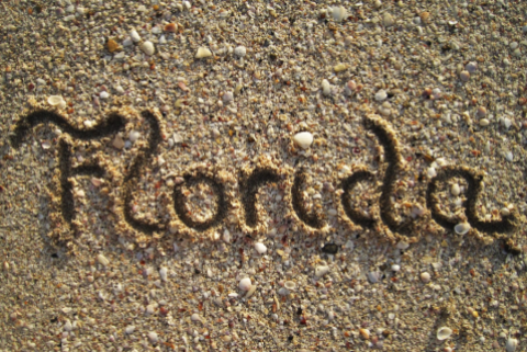 The word "Florida" written in the sand on a beach