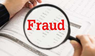 A magnifying glass overs over a spreadsheet, with the word "Fraud" superimposed in red text