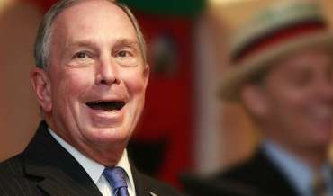 Former New York City mayor Michael Bloomberg smiles with his mouth open wide