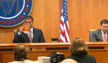 FCC Chairman Ajit Pai Drinks from a large mug with the Reese's peanut butter cup logo